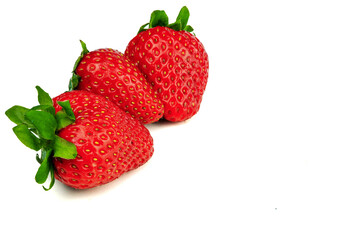 three strawberries on a white background, side view