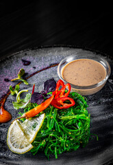 Chuka Seaweed Salad in plate on black wooden table background