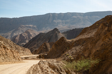 Naklejka na ściany i meble Gravel road and mountain landscape in Oman
