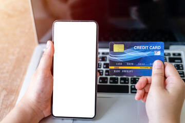 Close-up of freelance people business female Hand holding Credit cards casual and smartphone working using with laptop computer in coffee shop like the background,Online payment shopping concept