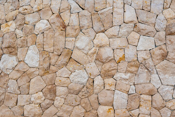 colored unprocessed rocky stones of natural origin, a wall of stones in concrete, background for walls and wallpapers