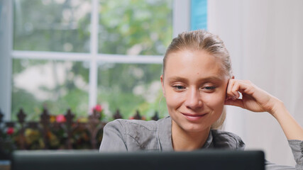 Happy woman freelancer working on laptop from home