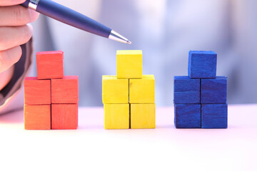 Businessman hand holding wooden cube block on table background and business concept growth success...