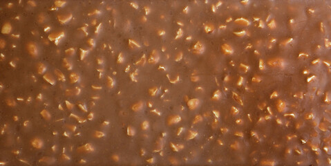Background texture banner made of chocolate bars with nuts. The concept of harmful sweet food and...