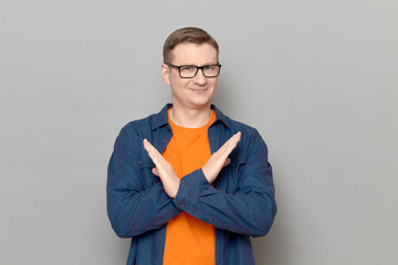 Portrait of happy man making cross with hands over chest and smiling
