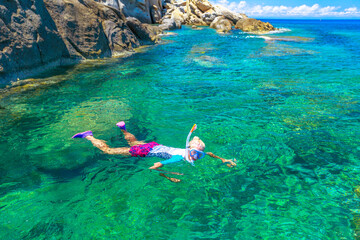 Female snorkeling in Sant 'Andrea beach and Cote Piane side in Elba island. Tourist woman in clear...