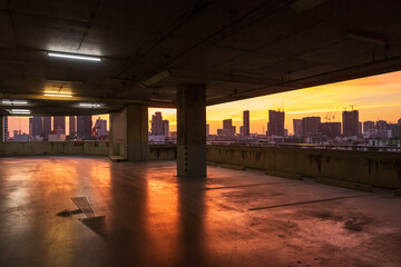 Parking garage and skyscraper city landscape background with beautiful sunset sky.