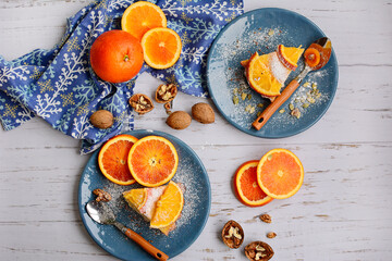 Homemade pie with citruses and orange slices on blue plates on a shabby wooden table. Rustic decor