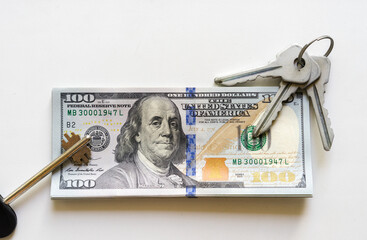 American one hundred dollar notes with house key and keyring. mortgage, credit, home purchase, real estate.