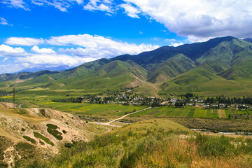 View of the gorge in the mountains. The village and the road. Summer landscape. Kyrgyzstan Issyk-ata gorge.