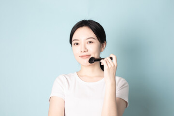 A Young Chinese Woman In Front of Blue Background