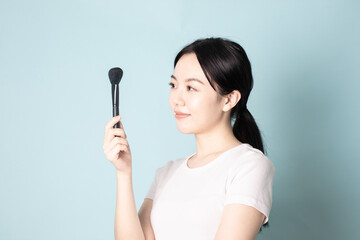 A Young Chinese Woman In Front of Blue Background