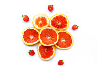 Grapefruits and strawberry on white background, top view. Citrus fruits. Slices of fresh orange
