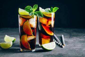 Rum and Cola Cuba Libre ice cold drink cocktail with lime and mint