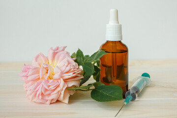 Rose and bottle with aromatic oil or medicine and syringe