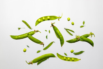 Flat lay composition with delicious fresh green peas levitating on white background