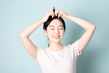 Fototapeta premium A Young Chinese woman in front of a blue background