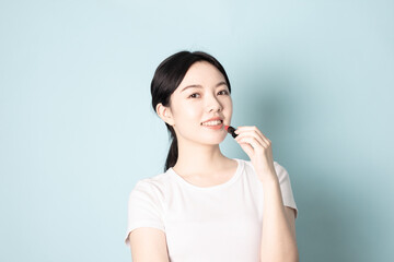 A Young Chinese woman in front of a blue background