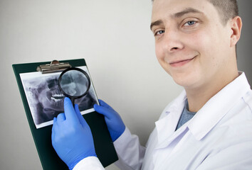 A dentist doctor examines a radiography of the teeth of a patient who has problems and teeth are...