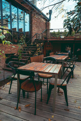 wooden tables and chairs in patio in a utumn