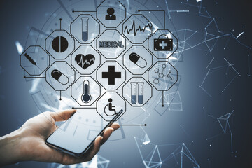 Hand holding mobile phone with glowing medical interface.