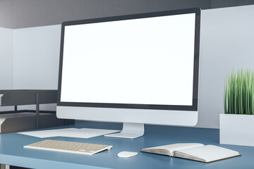 Modern office desk and computer with blank white screen.