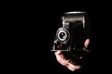 Vintage bellows camera in the hand of the photographer