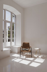 Empty white sunny room with wicker chair and table. Minimalist design