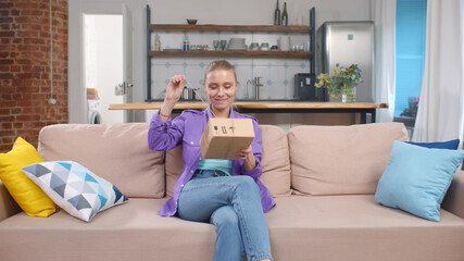 Millennial woman opening cardboard box with order