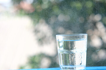 glass of water on wood table background and pouring drinking water
