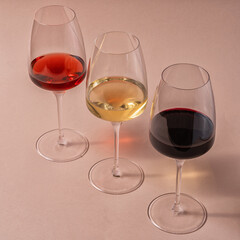 Glasses of red ,rose and white wine on pink background, top view.