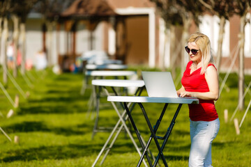 Portrait of a woman buying online or booking hotel with a laptop and credit card on the beach in vacations. E commerce concept