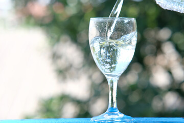 glass of water on wood table background and pouring drinking water