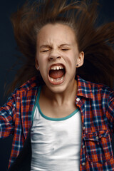 Little girl shouting in studio, developing hair