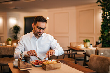 Businessman eating lunch in the restaurant, copy space, portrait.