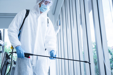 Man in virus protective suite and mask spraying alcohol cleaning covid19 infected area, Virus disinfection concept