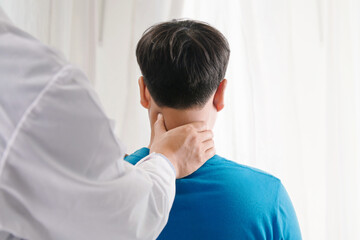 Doctor physiotherapist doing neck adjustment. stretching the Injured Neck of a Male Patient  in medical office.