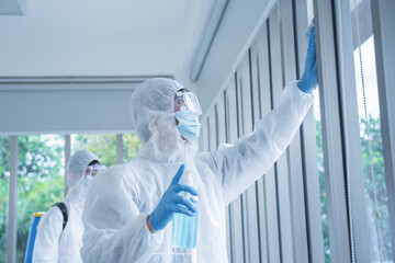 Specialist team in virus protective suite and mask spraying alcohol and cleaning covid19 infected...