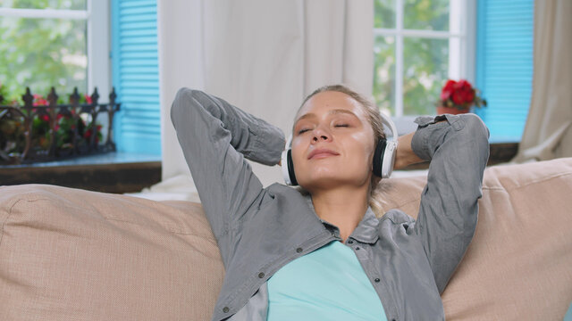 Young beautiful woman listens to music in headphones.