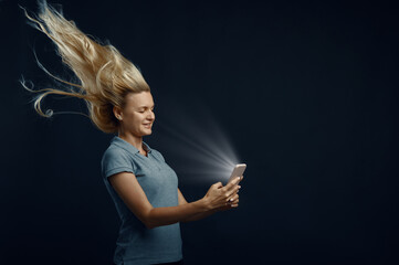 Woman looking on phone against powerful airflow