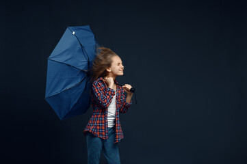 Little girl holds an umbrella, wind effect