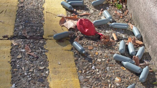 Nitrous Oxide canisters used for drugs on road Close up