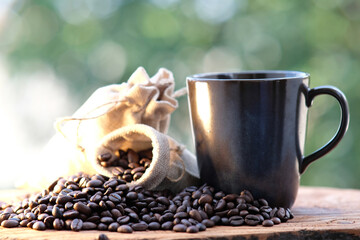 close up coffee beans and coffee cup on wood table background and space