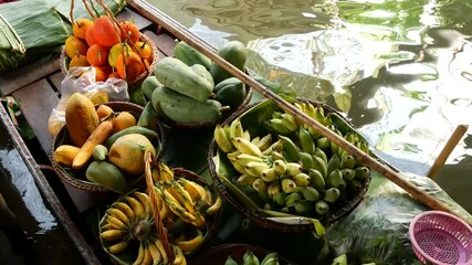 Iconic asian Lat Mayom floating market. Khlong river canal, long-tail boat with tropical exotic colorful fruits, organic locally grown vegetables. Top view of harvest and street food in wooden canoe. - Powered by Adobe