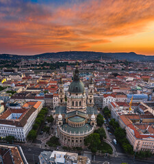 Obraz premium Budapest, Hungary - Aerial panoramic skyline view of St. Stephen's Basilica with a dramatic colorful sunset and Szechenyi Chain Bridge, Buda Castle Royal Palace, Buda Hills at background