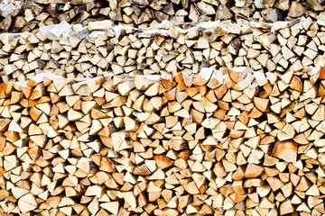 Stacked firewood close-up. Firewood storage close up. Stocks of wooden logs close-up. Chopping wood. Logging in the village. Rustic lifestyle. Woodpile with firewood full frame image. Wooden texture.