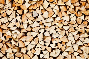 Stacked firewood close-up. Firewood storage close up. Stocks of wooden logs close-up. Chopping wood. Logging in the village. Rustic lifestyle. Woodpile with firewood full frame image. Wooden texture.