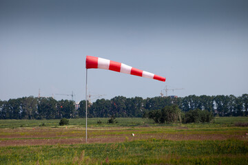 Windsock, weather vane for airfields. Red and white striped fabric showing wind speed, strength and...