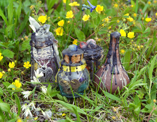  Witch potion bottles on the grass in the garden. Esoteric, gothic and occult background with magic...