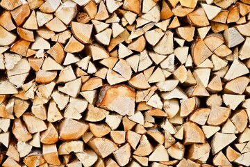 Stacked firewood close-up. Firewood storage close up. Stocks of wooden logs close-up. Chopping wood. Logging in the village. Rustic lifestyle. Woodpile with firewood full frame image. Wooden texture.